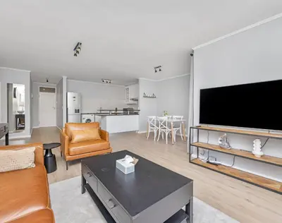 a living room with a large flat screen tv at Capri On Lake 101 The Island Club in Cape Town