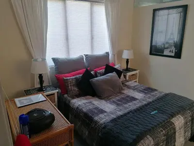 a bedroom with a bed with pillows and a window at HARTSRUS in Kleinmond
