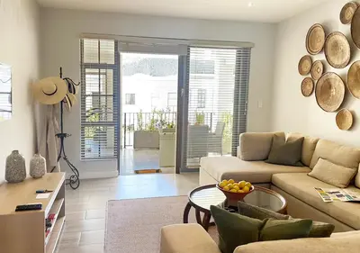 a living room with a couch and a table at Franschhoek Mountain Views in Franschhoek