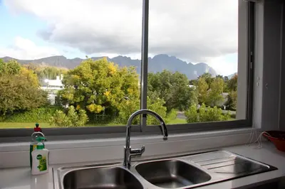 a kitchen sink and a window with a view of mountains at Franschhoek Mountain Views in Franschhoek