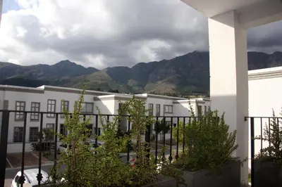 a white building with mountains in the background at Franschhoek Mountain Views in Franschhoek