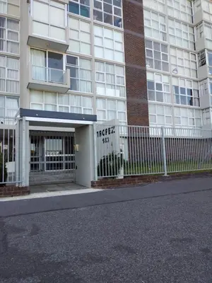 a building with a fence in front of it at Charming beachfront Strand apartment in Cape Town