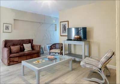 a living room with a couch a table and a tv at Sunset Terrace in Hermanus