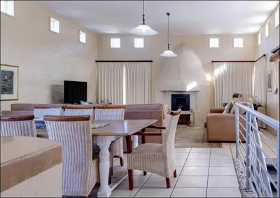 a dining room and living room with a table and chairs at Sunset Terrace in Hermanus