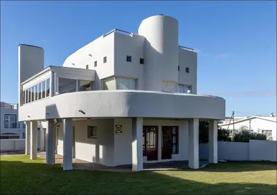 a white building with the front entrance to it at Sunset Terrace in Hermanus