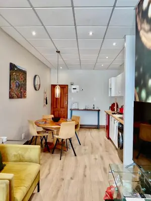 a living room and kitchen with a table and chairs at Pepper Korrel - Paarl - Self Catering Apartment in Paarl