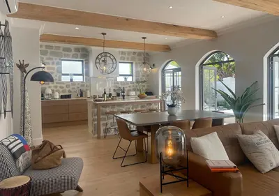 a kitchen and living room with a couch and a table at 2 Riverside Oaks in Franschhoek