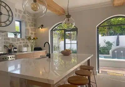 a kitchen with a large counter with stools in it at 2 Riverside Oaks in Franschhoek