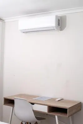 a desk with a white chair and a light above it at Meah lane , TableView in Cape Town