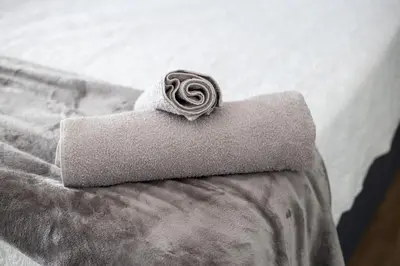 a rolled up towel sitting on top of a bed at Meah lane , TableView in Cape Town