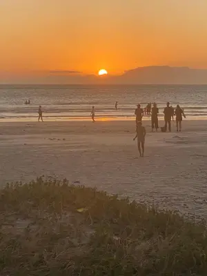 a group of people on the beach at sunset at Culemborg Court in Cape Town