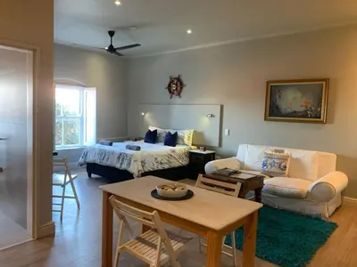 a bedroom with a bed and a living room at Hermanus Waterfront Apartment 12 in Hermanus