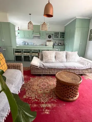 a living room with a couch and a table at Lala Panzi - Grotto Beach, Voëlklip in Hermanus