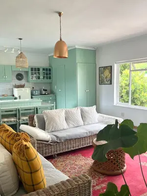 a living room with a couch and a kitchen at Lala Panzi - Grotto Beach, Voëlklip in Hermanus