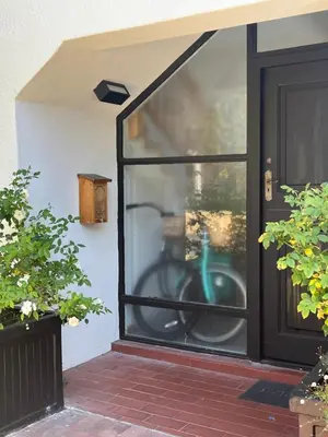a glass door with a green bike in it at Lala Panzi - Grotto Beach, Voëlklip in Hermanus