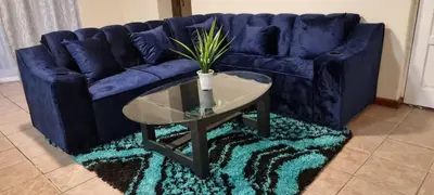 a blue couch with a table and a potted plant at McSheyson Apartment - Deluxe in Cape Town