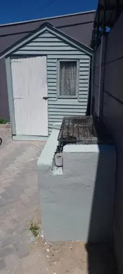 a garage with a white door and a building at McSheyson Apartment - Deluxe in Cape Town