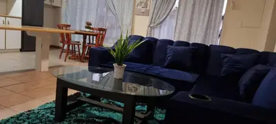 a living room with a blue couch and a table at McSheyson Apartment - Deluxe in Cape Town