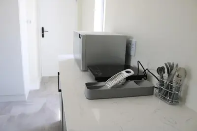 a kitchen counter with a coffee maker and a remote control at Digital Nomad's Nest, Somerset West in Cape Town