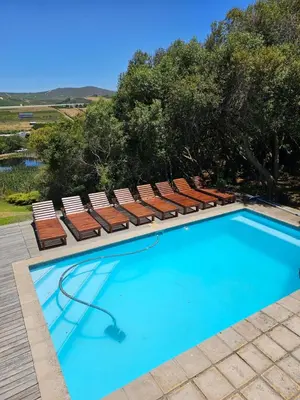 a swimming pool with lounge chairs and a swimming pool at Die Heerenhuys Guest Suites in Stellenbosch