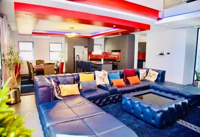 a living room with a blue couch with colorful pillows at Enclaves Villa in Cape Town