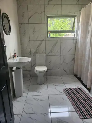 a bathroom with a toilet and a sink and a window at Excel accommodation in Cape Town
