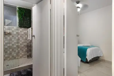 a bathroom with a shower and a bed in a room at Seaside Sunsets in Strand