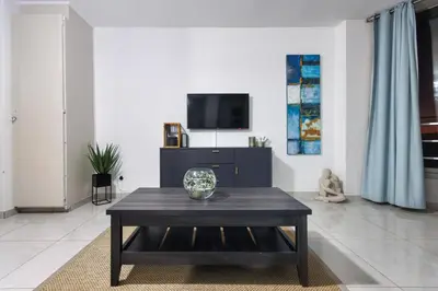a living room with a coffee table and a tv at Seaside Sunsets in Strand