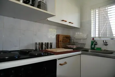 a kitchen with a stove top and a sink at Bradclin @ York in Cape Town