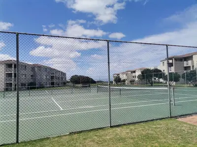a chain link fence with two tennis courts at Beach Club 47 Hermanus in Hermanus