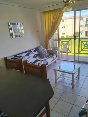 a living room with a bed and a table at Beach Club 47 Hermanus in Hermanus
