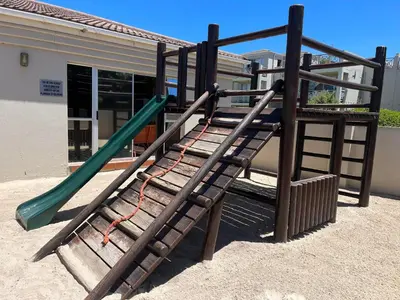 a playground with a slide in front of a building at #FiftySeven in Hermanus