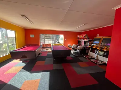 a gaming room with two pool tables and arcade games at #FiftySeven in Hermanus