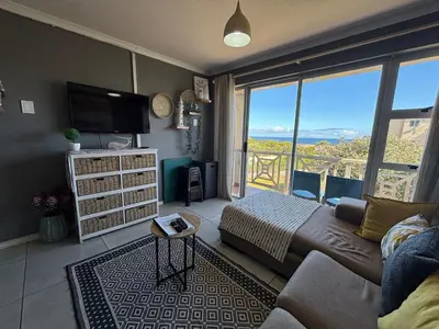 a living room with a couch and a large window at #FiftySeven in Hermanus