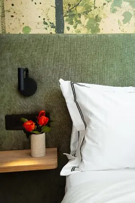 a bed with white pillows and a vase with red flowers at Paarl Hideaway in Paarl