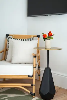 a chair and a table with a vase of flowers at Paarl Hideaway in Paarl