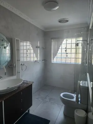 a white bathroom with a sink and a toilet at Cape Town gem 