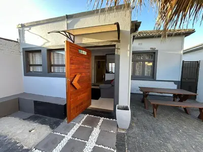 a house with a wooden door and a picnic table at 57onWYNNE in Cape Town
