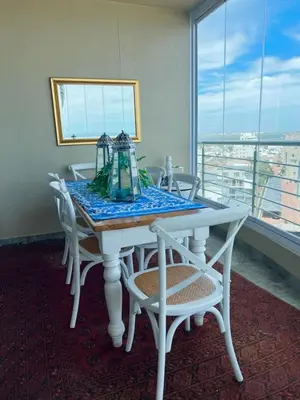 a dining room table with white chairs and a window at Portico 705 in Cape Town