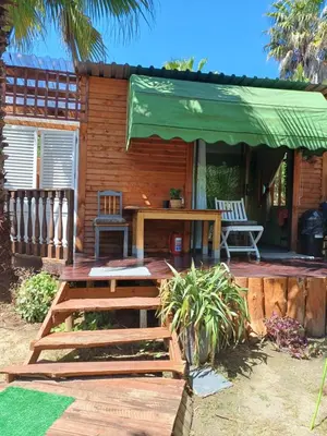 a wooden deck with a table and a green umbrella at The Farmhouse Palm Tree Cabin in Stellenbosch