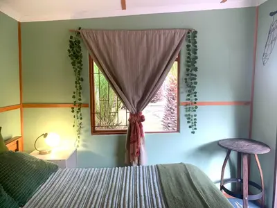 a bedroom with a bed and a window at The Farmhouse Palm Tree Cabin in Stellenbosch