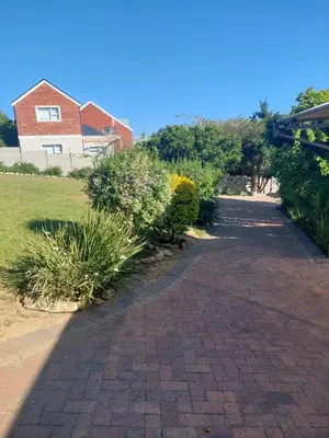 a brick driveway with plants and a house in the background at Sophia’s Cottage in Cape Town
