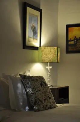 a bedroom with a bed with a pillow and two lamps at Wildekrans Country House in Botrivier