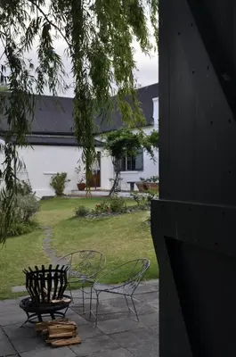 a patio with a table and chairs and a building at Wildekrans Country House in Botrivier
