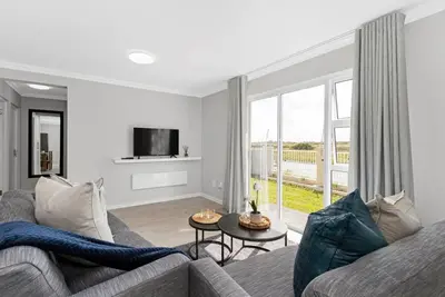 a living room with a couch and a tv at Elegant, Spotless 2 Bed For Enchanted Stays in Cape Town