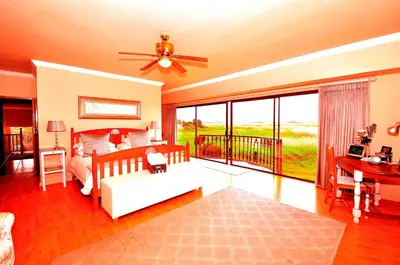 a living room with a couch and a ceiling fan at Casa Mia Guesthouse in Table View