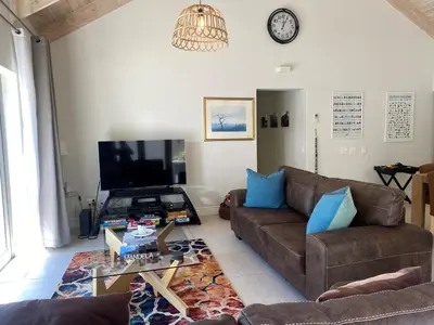 a living room with a couch and a tv at Leopard Tree Cottage in Franschhoek