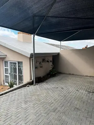 a house with a blue umbrella over a patio at the Vine in Cape Town