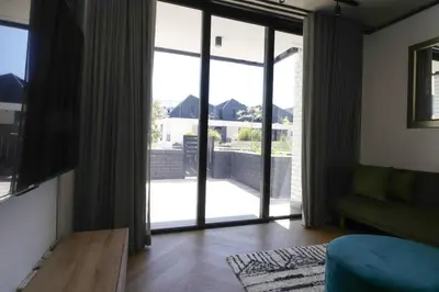 a living room with a large sliding glass door at Modern apartment in Century City in Cape Town