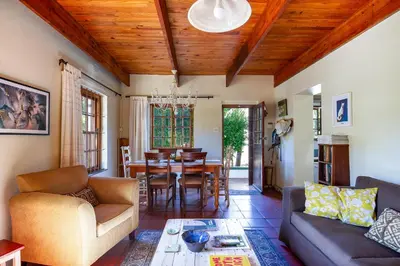 a living room with a couch and a table at Bluebelle Cottage in Greyton